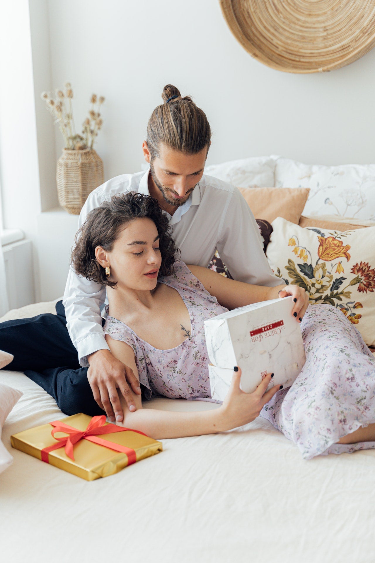 Couple on bed opening gifts