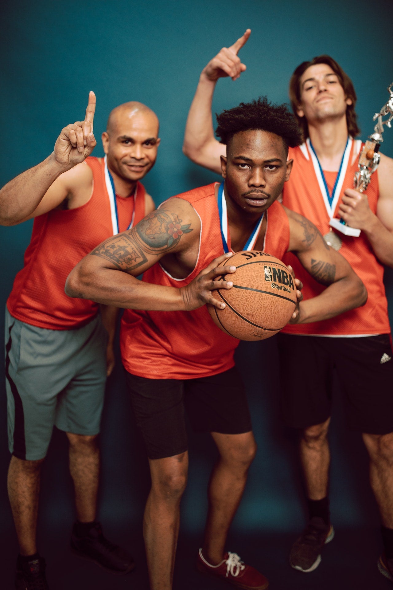 Three basketball players with custom engraved trophy and medals